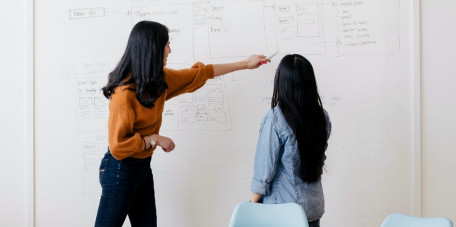 社内でのミーティングイメージ画像です。ホワイトボードにまとめながら、議論を進めています。