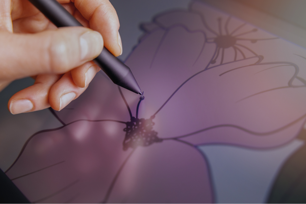 タブレットでピンク色の花を描く様子。サイトのイメージカラーに合わせたイラスト制作の場面。